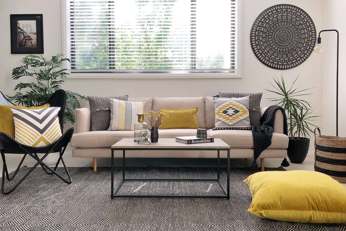Neutral sofa accentuated with patterned and texture cushions in grey and mustard for a pop of colour.