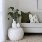 Two olive coloured cushions from the set of 5 Ava sofa cushions are displayed on a grey sofa.