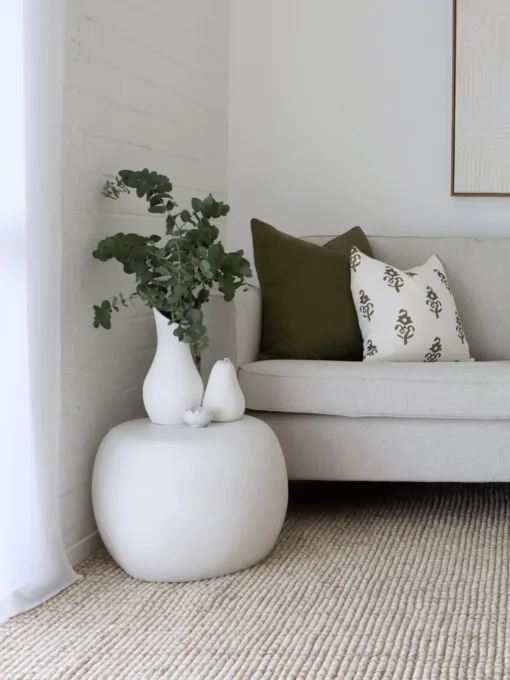 Two olive coloured cushions from the set of 5 Ava sofa cushions are displayed on a grey sofa.