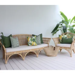 Outdoor sofa adorned with seven olive cushions snugly surrounded by lush greenery.