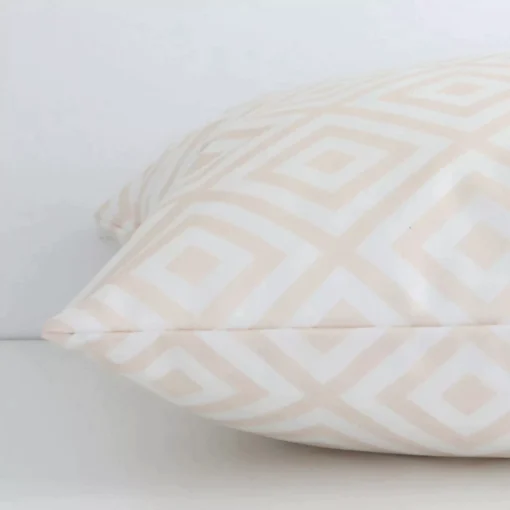 Side angle shot of outdoor square cushion cover. The beige geometric printed on it is shown along its seams.