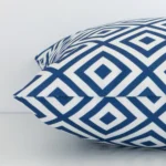 Horizontal edge view of front and back panels of a geometric outdoor cushion in a square size and with blue colouring.