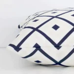 Lateral viewpoint of this outdoor square cushion. The navy and beige geometric design is shown from the side showing the front and rear panels.