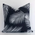 A graceful square black-and-white cushion with a palm style on durable outdoor fabric.