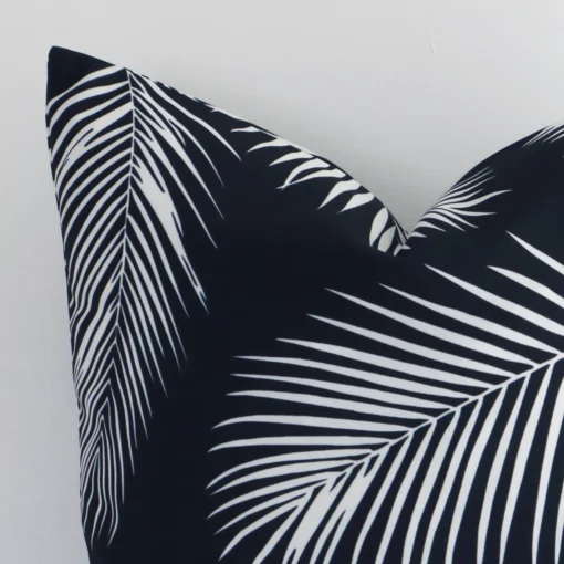 An outdoor square cushion’s corner has been enlarged in this shot. The detail of the palm design and black and white colour are visible.