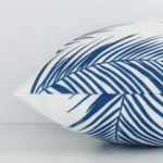 A rectangular outdoor cushion positioned flat to show its seams. The blue colour and palm design are visible as is the seam between the panels.