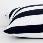 Large black and white cushion laid flat. This view shows the stripe style and outdoor fabric from side on.