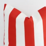 A macro image of the top left corner of this outdoor cushion. It is possible to see the finer detail of the large size and red stripe colour.