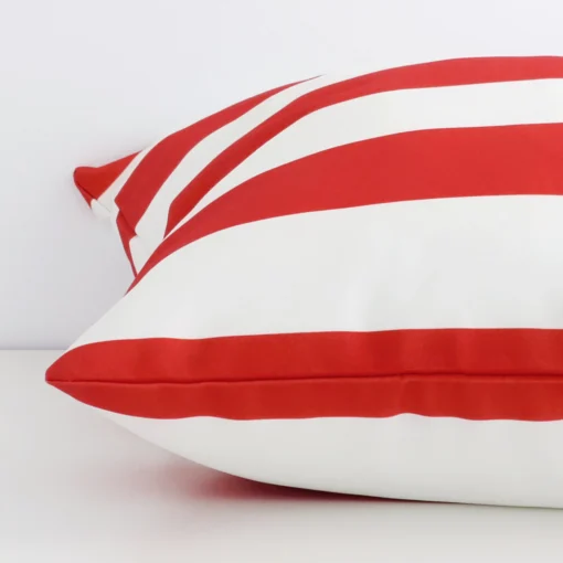 The edge of this outdoor large cushion in red stripe is shown. The shot shows the front and rear panels.