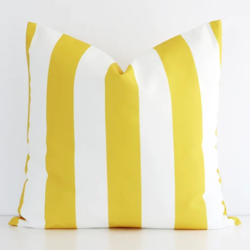 Yellow striped cushion cover in front of a white wall. It has a large size and is made from an outdoor material.