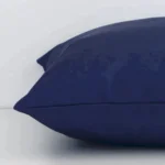 Outdoor navy cushion laying on its side. The design and its square size are visible.