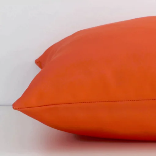 Square outdoor cushion cover positioned flat to show seams. The orange hue and solid colour design are shown between front and rear fabric panels.