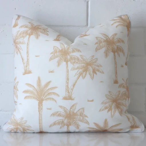 An outdoor square cushion cover that has a unique design is shown vertically against a brick wall. It has a wonderful beige colour.
