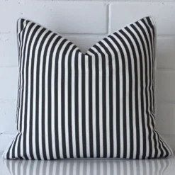 A square cushion in a delightful black and white tone rests against a white wall. The outdoor material appears to be of exceptional quality.