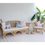 7 pink cushions on an outdoor sofa nestled amidst vibrant greenery.