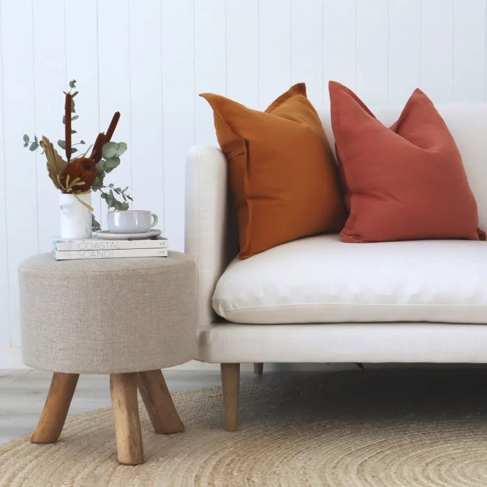 A red and an orange linen cushion on a white sofa