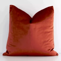 A graceful square rust cushion with a solid colour style on durable velvet fabric.