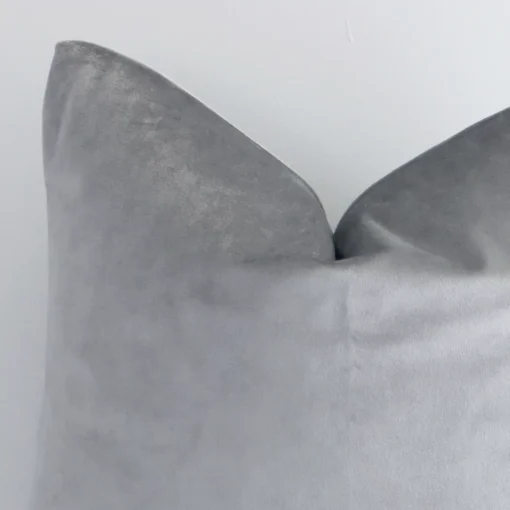 Zoomed photo of the top left corner of this silver solid-coloured cushion cover. The image clearly shows the velvet material and square shape.