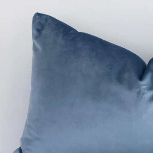 This image shows a stone blue solid-coloured cushion cover from a very close range. The rectangular size and velvet material are more clearly shown.